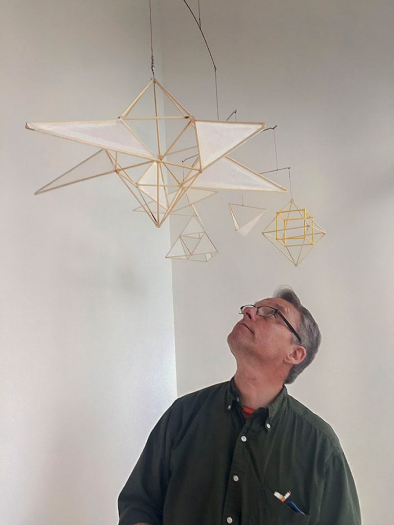 Artscapes alumnus Roger Ralston standing next to his mobile Artscape installation in the Woolworth windows. Photo by Lisa Nappa.